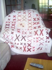 a white quilt covered with pairs of red X's