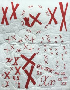 white quilt covered with pairs of red X's