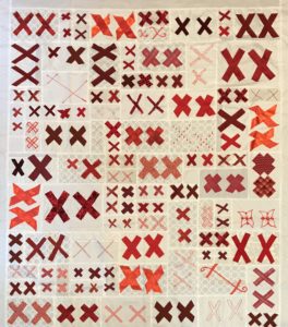 Pairs of red X’s cover a white cloth