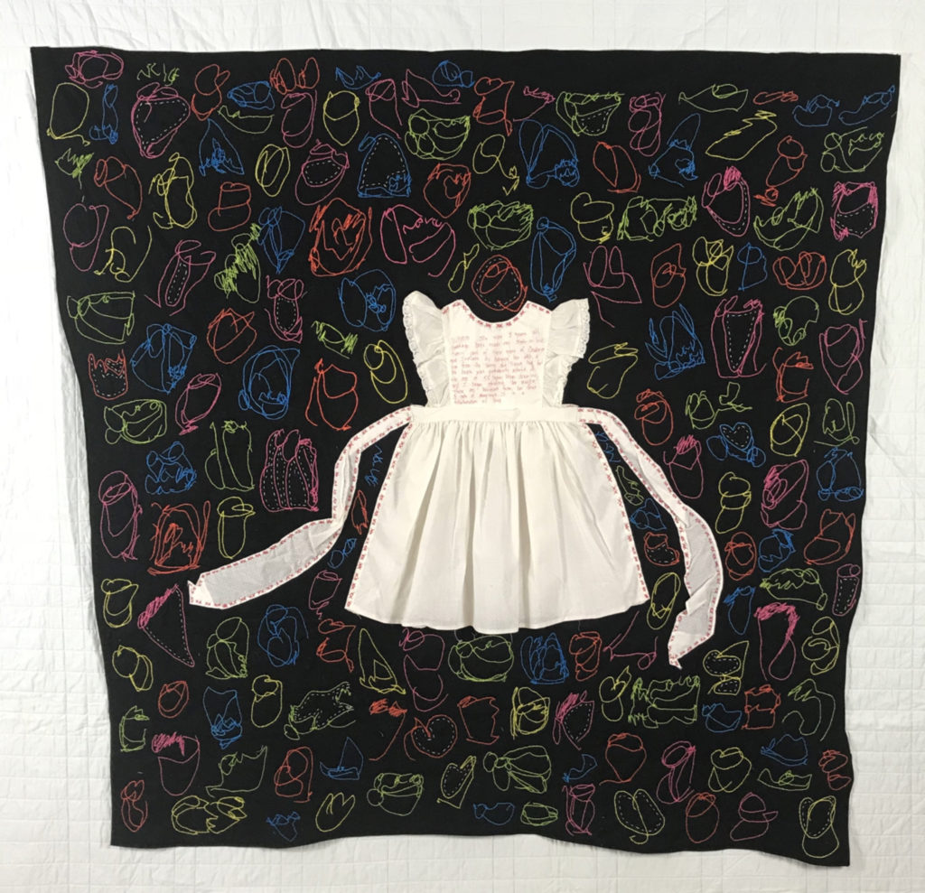 little girl's white dress with sash sewn over a black quilt filled with colorful stitched scribbles