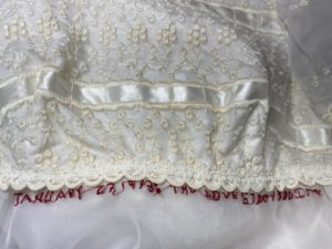 Red text embroidered on wedding dress