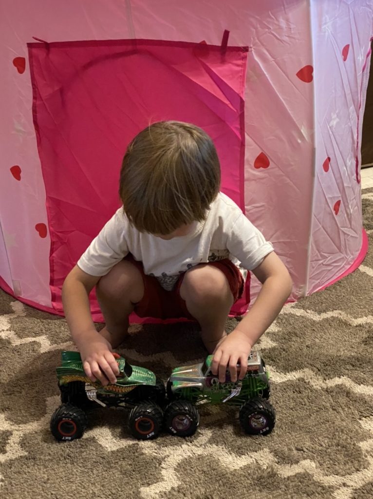 the young boy puts two toy trucks together