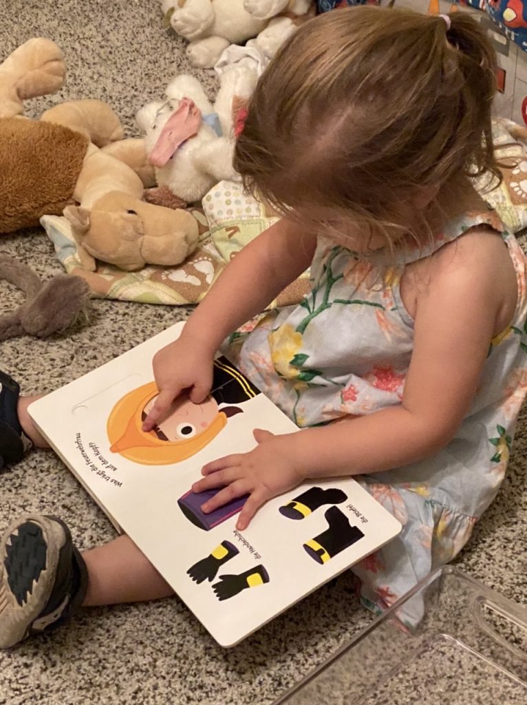 a little girl reads a book about firemen